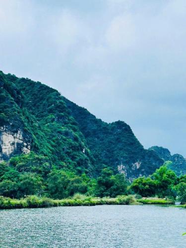 a large body of water with mountains in the background at Tràng An Sunny River Homestay in Ninh Binh