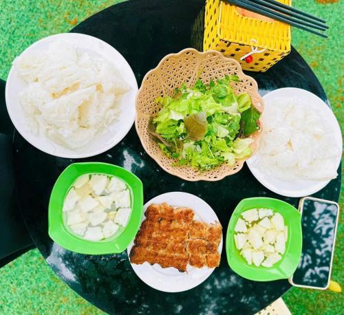 a table with plates of food on a table at Tràng An Sunny River Homestay in Ninh Binh