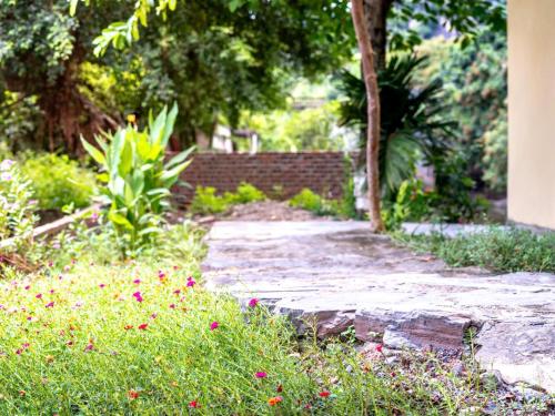 a stone walkway in a garden with flowers at Tràng An Sunny River Homestay in Ninh Binh