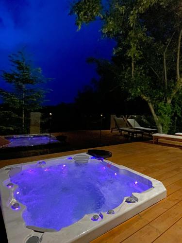 a small pool of purple water at night at Zloty, a Skromny - ogrodzony domek z jacuzzi i widokiem na jezioro in Górzno