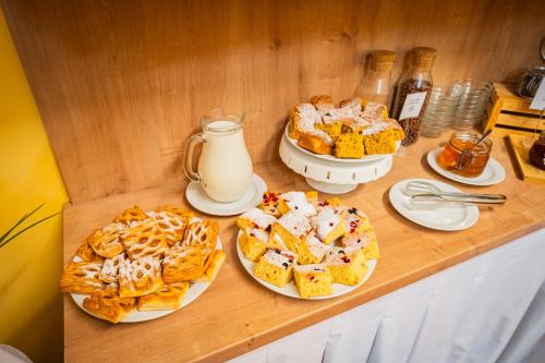 a table topped with plates of pastries and milk at Hotel Atos in Prague