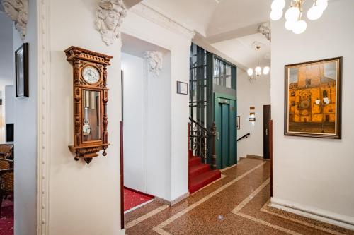 a hallway with a clock on the wall and a staircase at Hotel Atos in Prague
