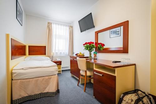 a hotel room with a desk and a bed and a desk at Hotel Atos in Prague