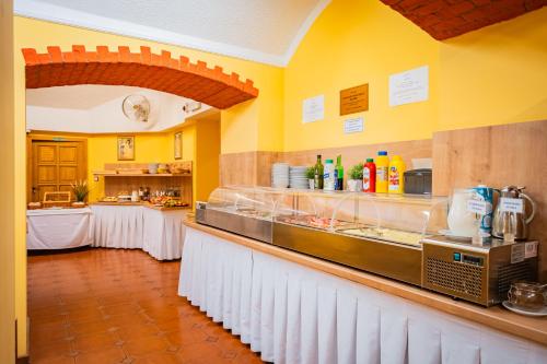 a kitchen with a counter with two tables in a kitchen at Hotel Atos in Prague