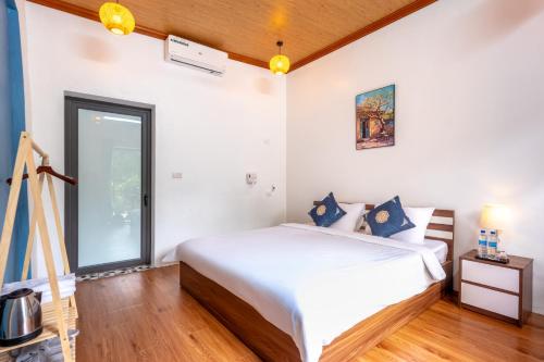 a bedroom with a bed and a large window at Tràng An Sunny River Homestay in Ninh Binh