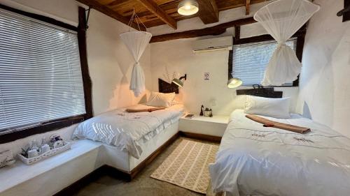 a bedroom with two beds and a tub in it at Roy's Rest Camp in Groutfontein