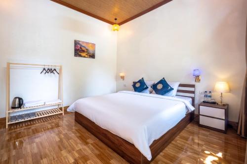 a bedroom with a large white bed and a window at Tràng An Sunny River Homestay in Ninh Binh