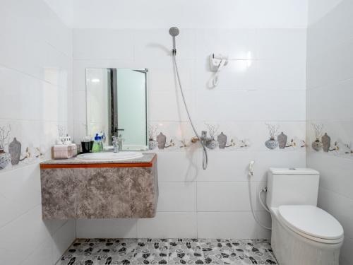 a bathroom with a toilet and a sink and a mirror at Tràng An Sunny River Homestay in Ninh Binh