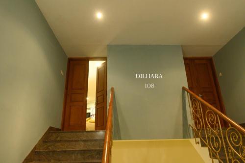 a stairway with a blue wall with the words diliha tucci on at Villa 53 in Battaramulla