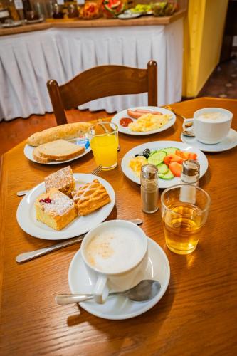 a table with plates of breakfast food on it at Hotel Atos in Prague