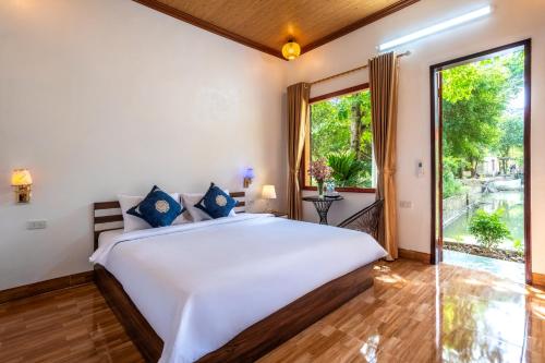 a bedroom with a large bed and a large window at Tràng An Sunny River Homestay in Ninh Binh