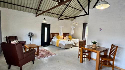 a living room with a bed and a table and chairs at Roy's Rest Camp in Groutfontein
