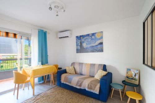 un salon avec un canapé bleu et une table dans l'établissement Cros de Cagnes 2 pièces - det001, à Cagnes-sur-Mer