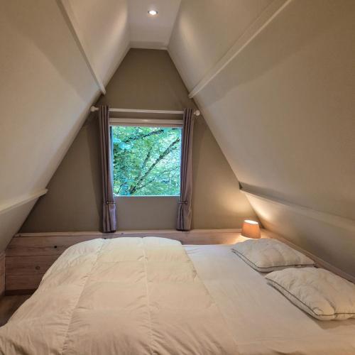 a bedroom with a large bed with a window at Tipi d'Amis in Durbuy