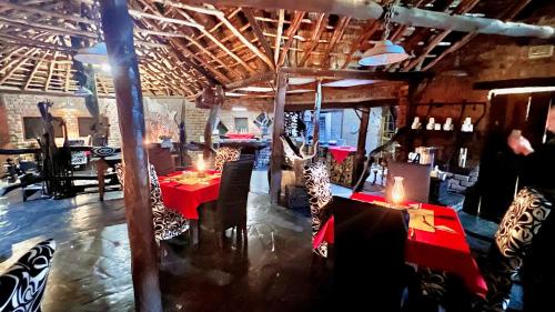 a restaurant with red tables and chairs in a room at Roy's Rest Camp in Groutfontein