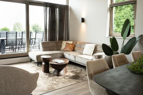 a living room with a couch and a table at Kooparc vakantiepark in Giesbeek