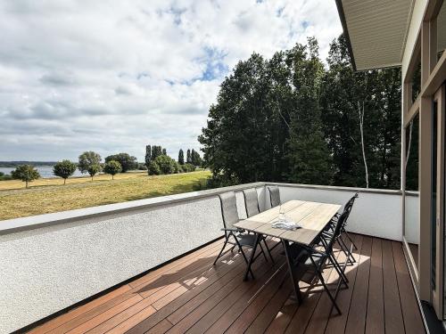 a wooden deck with a table and chairs on a balcony at Kooparc vakantiepark in Giesbeek