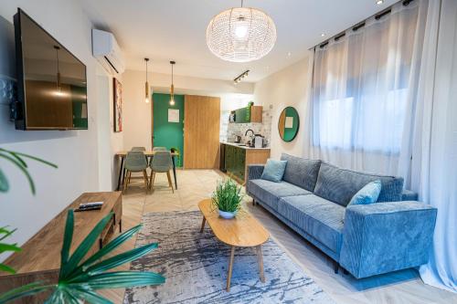 a living room with a blue couch and a table at Almogim Suites Eilat Hotel in Eilat