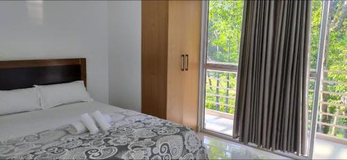 a bedroom with a bed and a large window at Vi-ki guest house in Dimapur