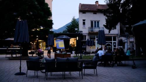 a group of chairs and tables with umbrellas and a building at Hotel Etropol, Center Etropole in Etropole