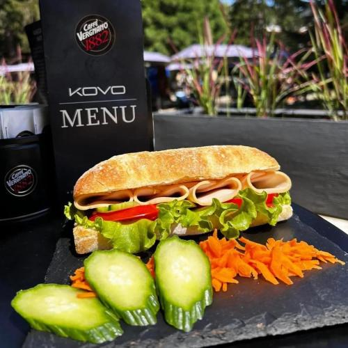 a sandwich on a plate with cucumbers and carrots at Hotel Etropol, Center Etropole in Etropole