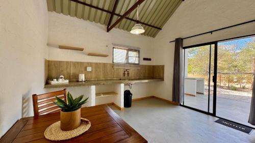 a living room with a table and a large window at Roy's Rest Camp in Groutfontein