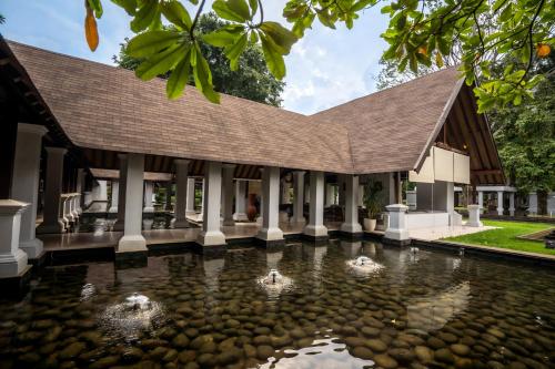 a pavilion with a pond in front of a building at Novotel Bogor Golf Resort in Bogor