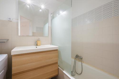 une salle de bain avec un lavabo, un miroir et une baignoire dans l'établissement Cros de Cagnes 2 pièces - det001, à Cagnes-sur-Mer
