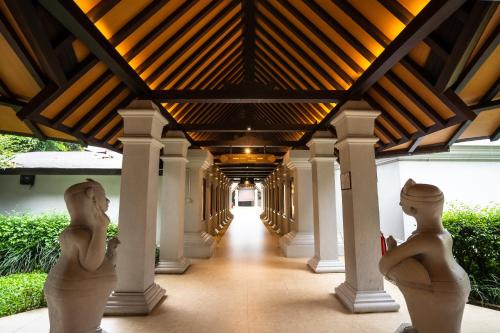 a hallway of a building with two statues in the middle at Novotel Bogor Golf Resort in Bogor