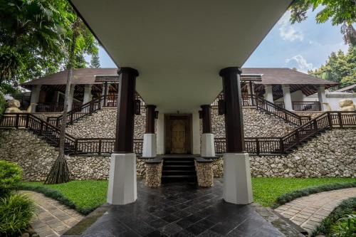 an entrance to a house with a stone wall at Novotel Bogor Golf Resort in Bogor