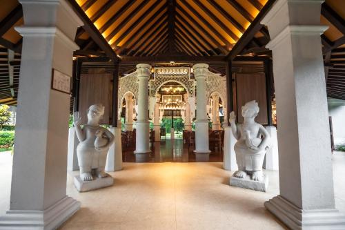 a hallway with statues in front of a building at Novotel Bogor Golf Resort in Bogor