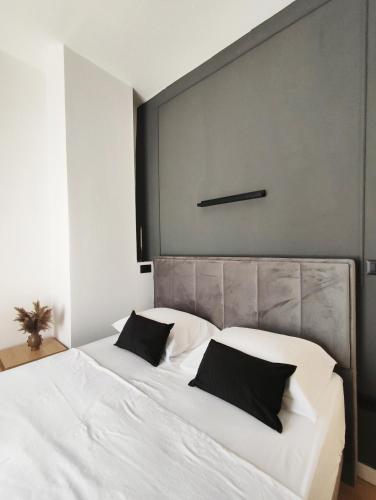 a bedroom with a large white bed with black pillows at Antoni Apartment in Lastovo