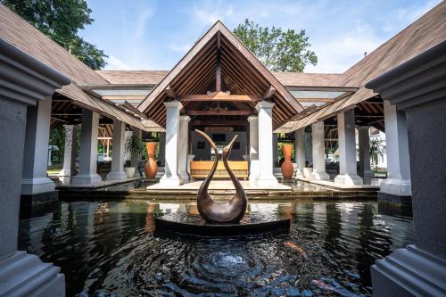 a building with a statue in the middle of the water at Novotel Bogor Golf Resort in Bogor