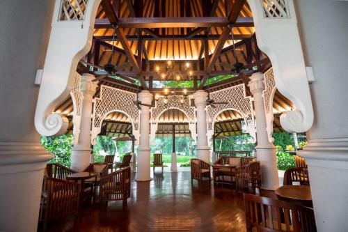 a restaurant with tables and chairs and a large ceiling at Novotel Bogor Golf Resort in Bogor