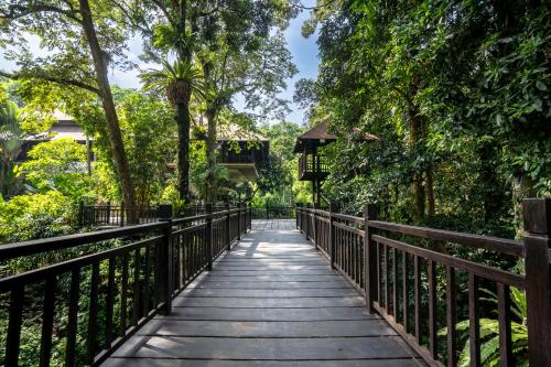 a wooden bridge in a park with trees at Novotel Bogor Golf Resort in Bogor