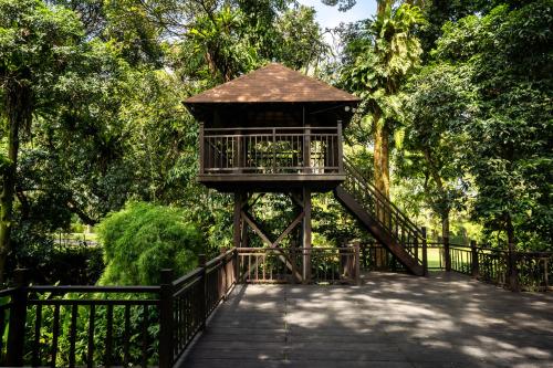 a wooden gazebo with a staircase in a park at Novotel Bogor Golf Resort in Bogor