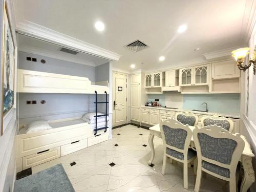 a kitchen with white cabinets and a table and chairs at Lan Rung Beach Resort in Long Hai