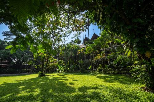a yard in front of a house with trees at Novotel Bogor Golf Resort in Bogor