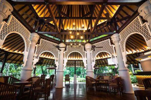 a dining hall with chairs and a chandelier at Novotel Bogor Golf Resort in Bogor