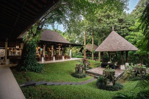 a garden with a pavilion and a building at Novotel Bogor Golf Resort in Bogor