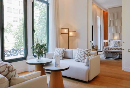 a living room with a white couch and tables at Hospes Palau de La Mar, Valencia, a Member of Design Hotels in Valencia