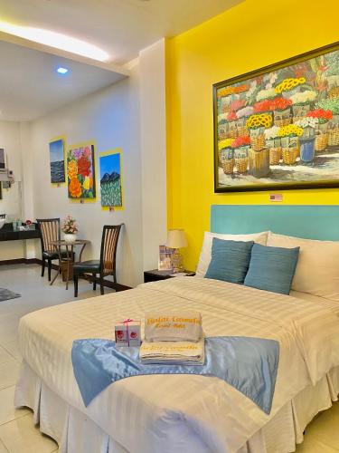 a bedroom with a large bed with a painting on the wall at Balai Carmela in Tuguegarao City