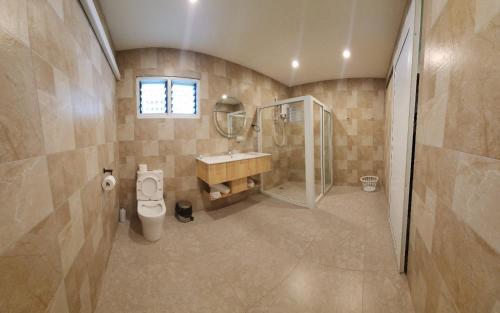 a bathroom with a toilet and a sink and a shower at Island Accommodation Suva Premier Hospitality in Suva