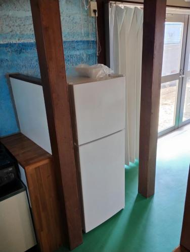 a white refrigerator in a room with a window at Unwind DAY OFF Nagamo in Yaese