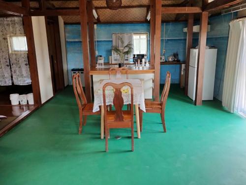 a kitchen with a table with chairs and a refrigerator at Unwind DAY OFF Nagamo in Yaese