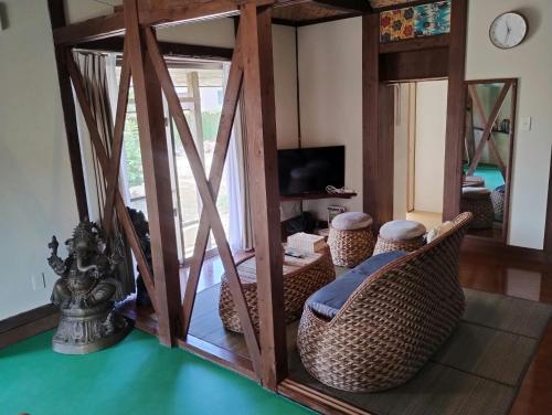 a living room with wicker chairs and a mirror at Unwind DAY OFF Nagamo in Yaese
