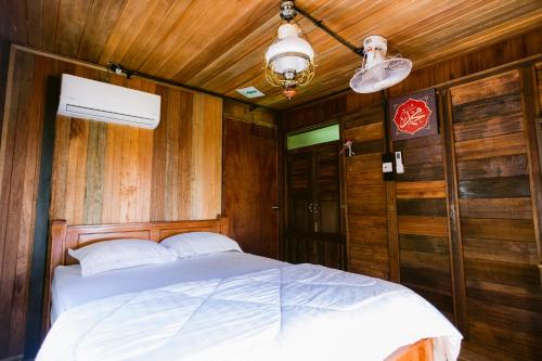 a bedroom with a bed in a room with wooden walls at KLIA Transit Homestay Tun Fatimah in Banting