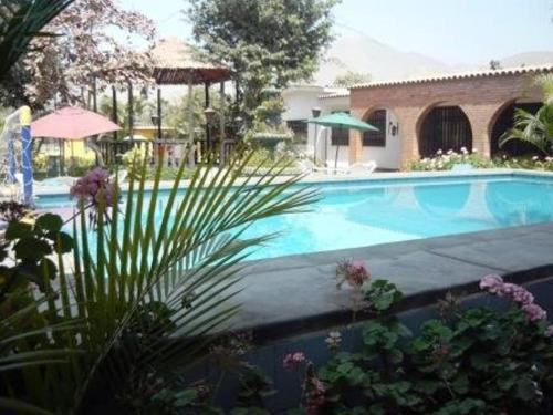 a large swimming pool in a yard with a house at Cieneguilla MolinoVerde in Cieneguilla