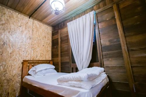 a small bedroom with a bed with a curtain at KLIA Transit Homestay Tun Fatimah in Banting