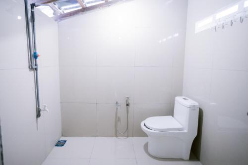 a white bathroom with a toilet and a shower at KLIA Transit Homestay Tun Fatimah in Banting
